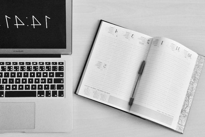 a planner and a laptop on a desk